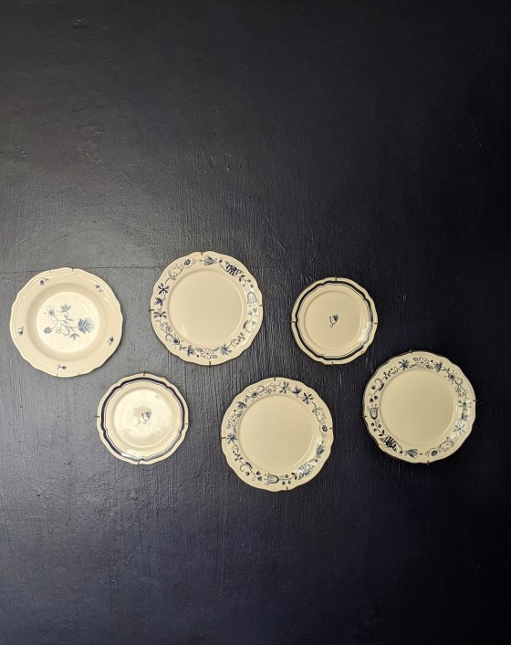 navy blue wall with plates hanging on it decoratively.